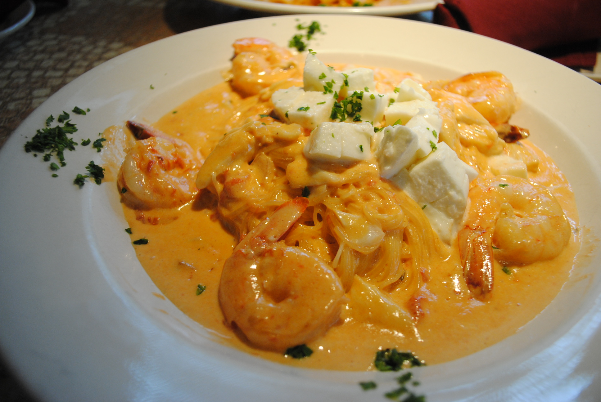 A plate of pasta with shrimp and cheese.